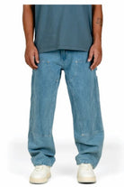 Person wearing light blue jeans and white sneakers on a white background