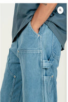 Person wearing blue jeans and a matching shirt on a white background