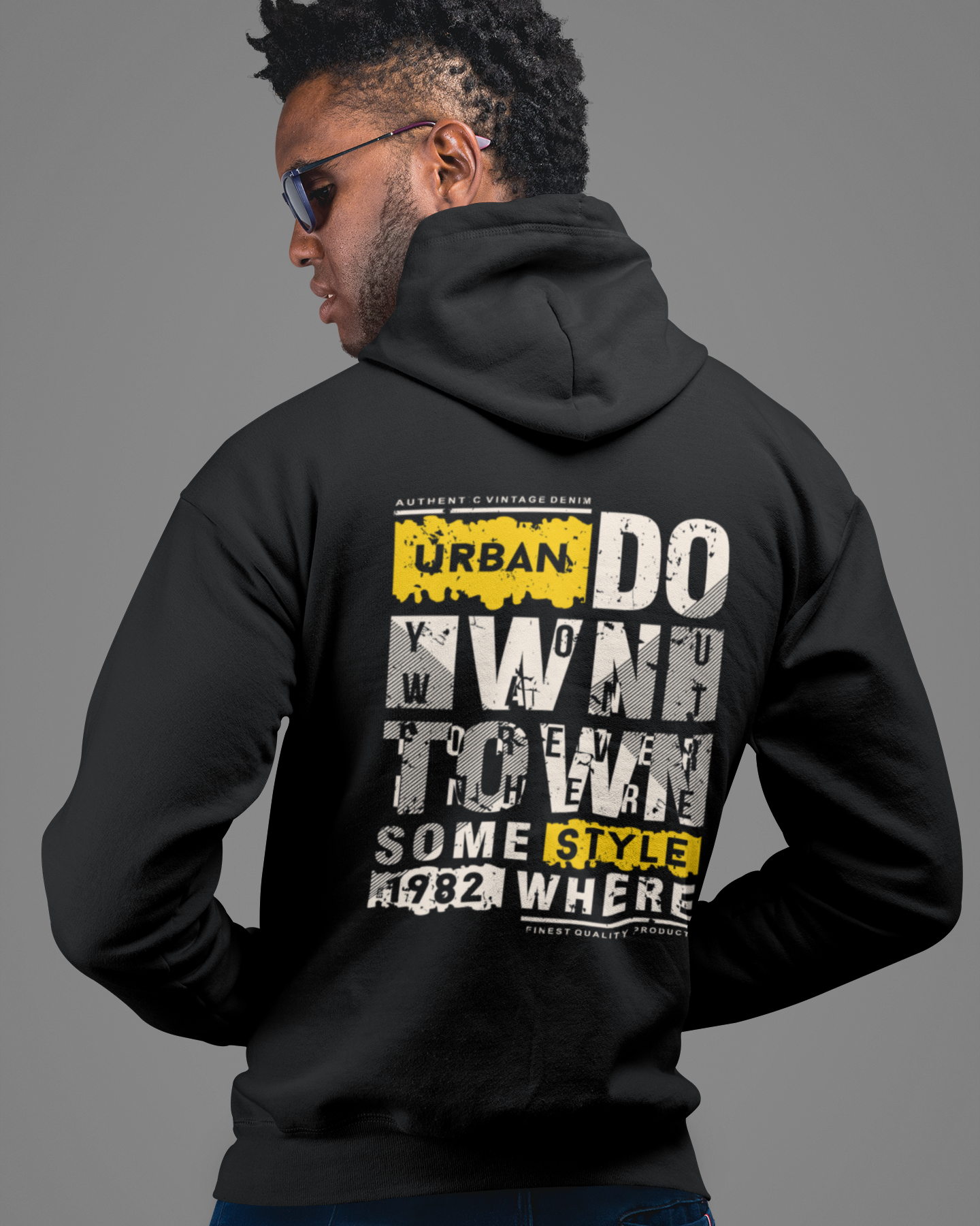 Person wearing a black hoodie with text on the back against a gray background