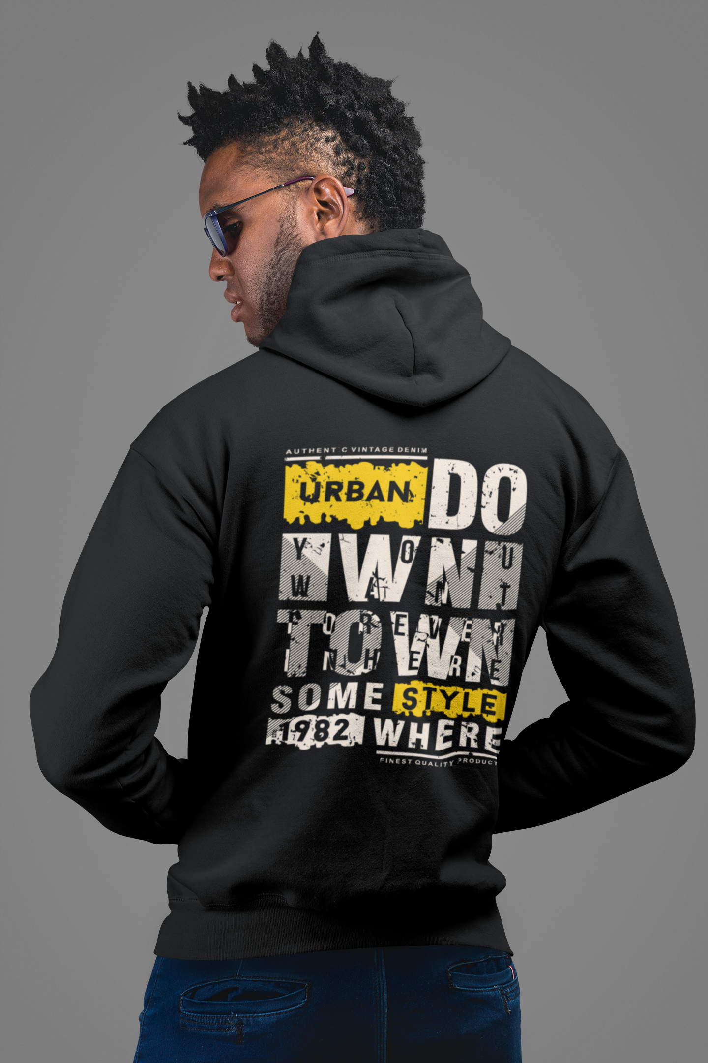 Person wearing a black hoodie with text on the back against a gray background