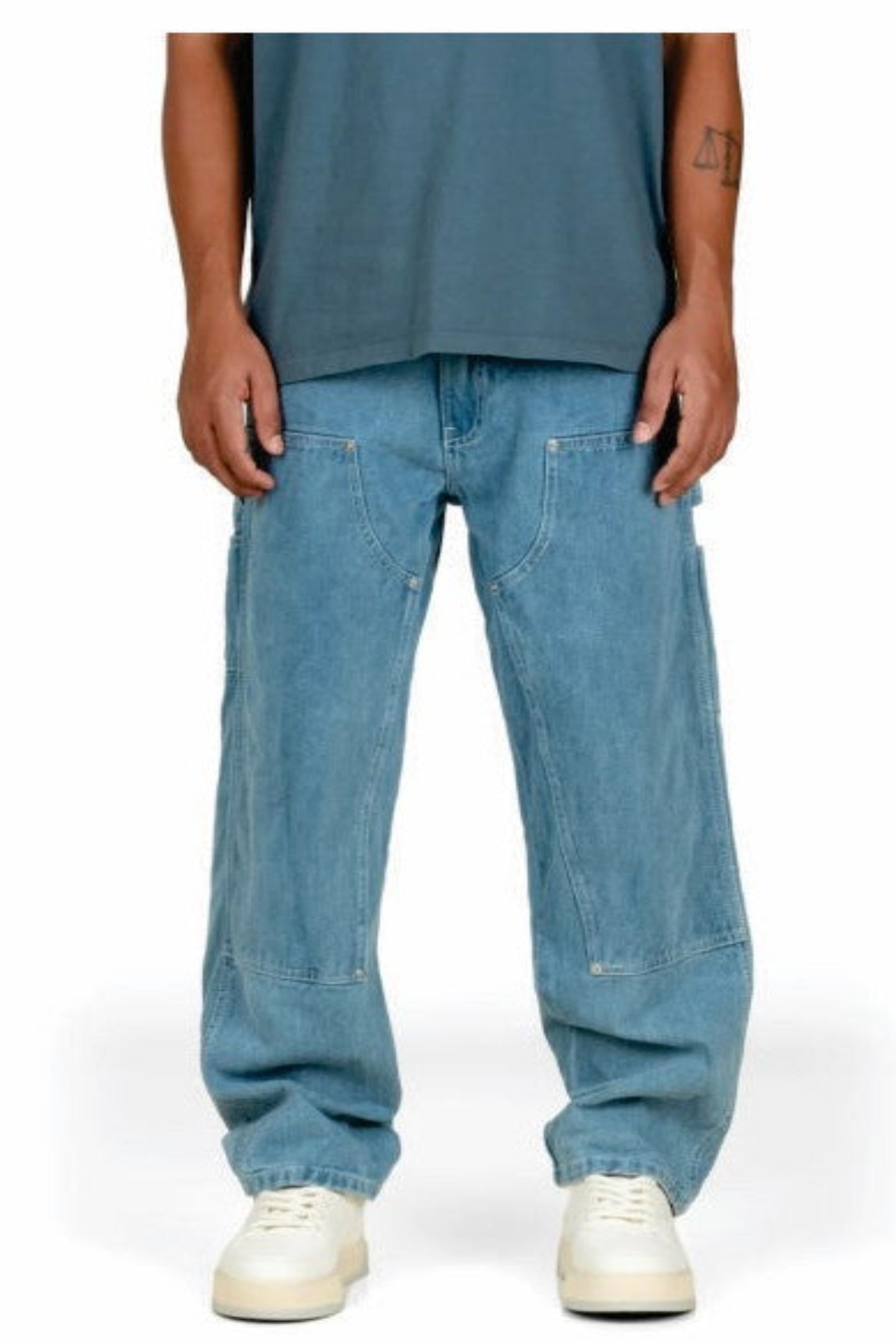 Person wearing light blue jeans and white sneakers on a white background