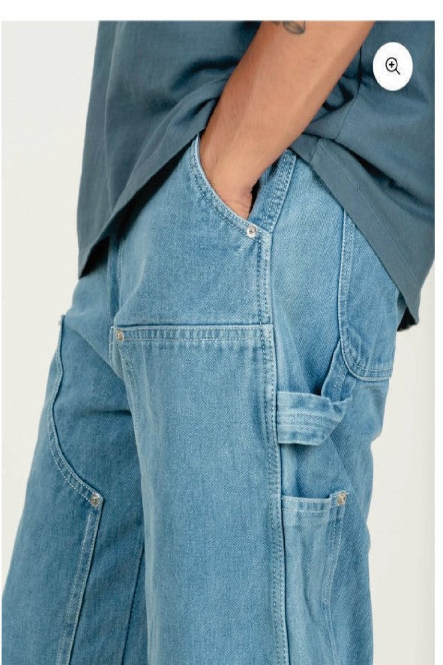 Person wearing blue jeans and a matching shirt on a white background