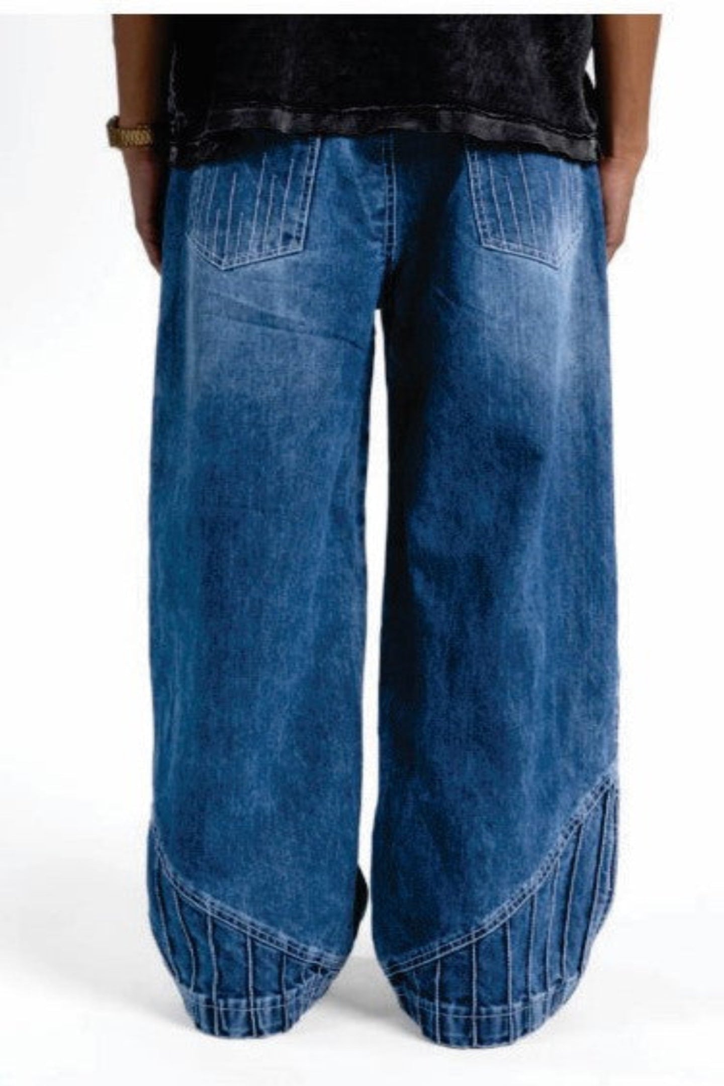 Wide-leg blue jeans worn by a person on a white background